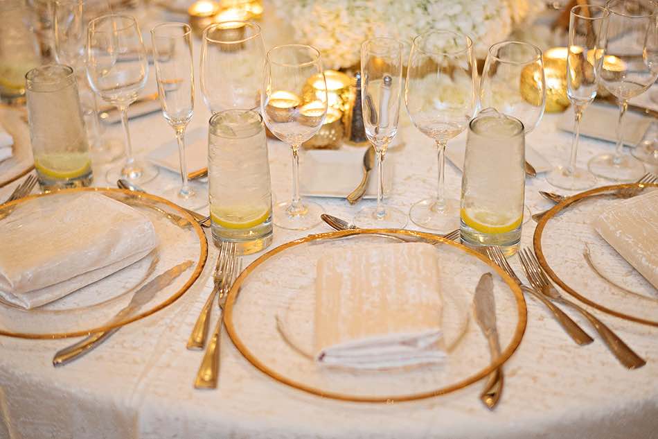 Jewish wedding A Chair Affair gold rim chargers at reception