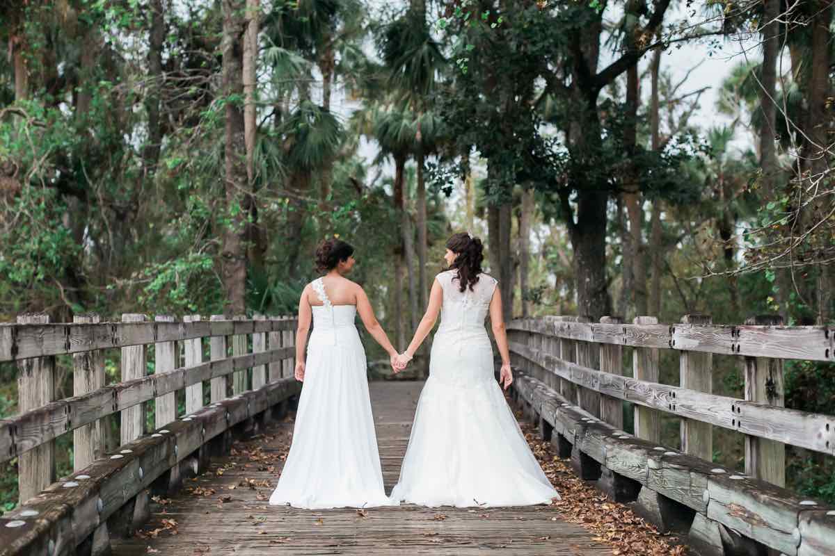 intimate LGBT wedding Reunion Resort A Chair Affair brides on bridge