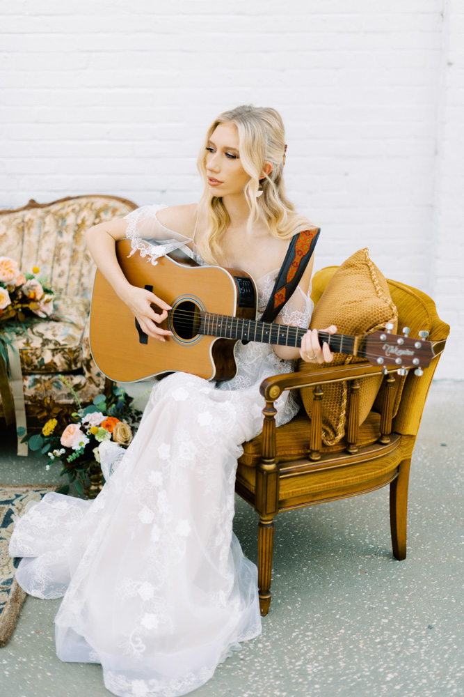 Model with guitar on vintage chair