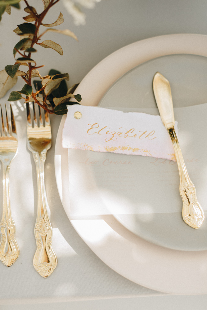 details of place setting with gold baroque flatware