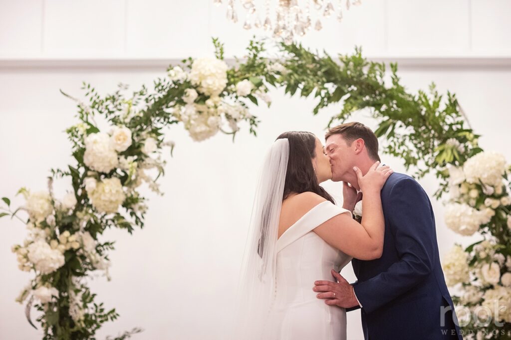 Bride and groom sharing first kiss during ceremony. New Smyrna wedding rentals