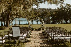 Outdoor wedding ceremony. A Chair Affair provided all the Central Florida wedding rental needs. Including the Black Chiavari Chairs with white pads.