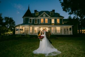 The Highland Manor wedding bride and groom pictured in front of the venue at night.
