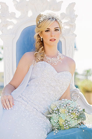 Bride sitting on and icy themed throne in her wedding gown