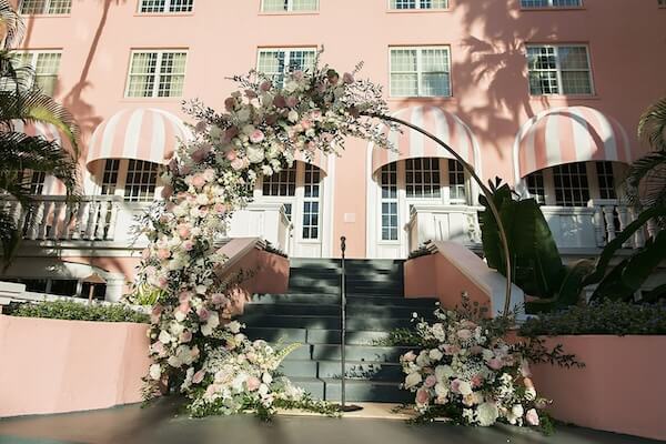 The moon gate wedding arch wrapped in pink and white flowers used for the wedding ceremony at the Don Cesar