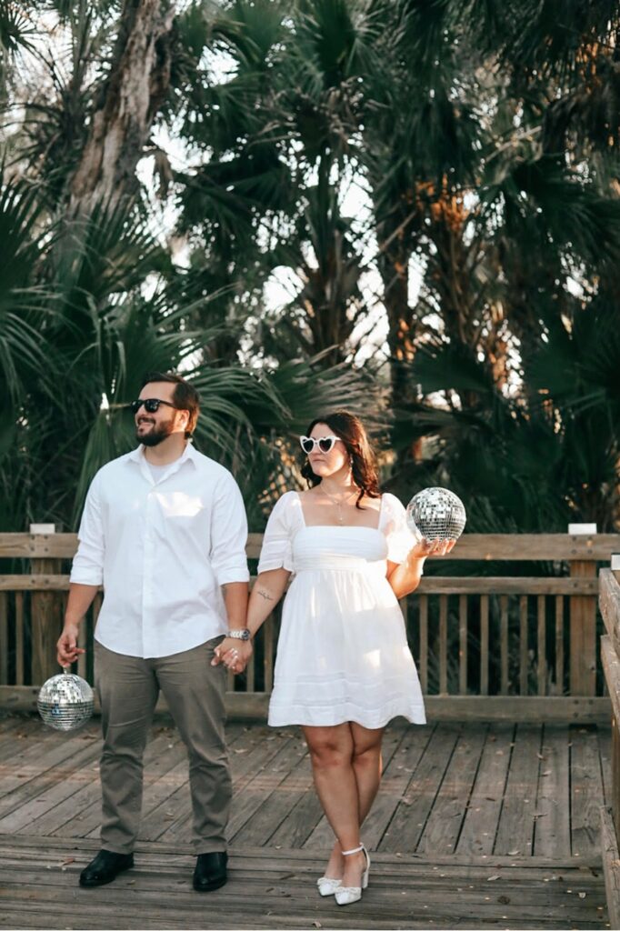 July monthly wedding winners photo captured on a bridge outdoors with trees in the background and both wearing sunglasses