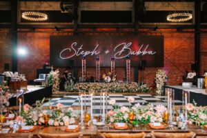 The checkered dancefloor and large sign with Steph and Bubba on it above the stage that the band performs on