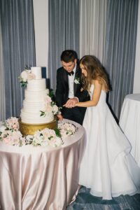 The bride and groom both cutting their wedding cake during the reception