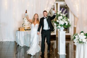The bride in groom entering the reception with drinks in hand