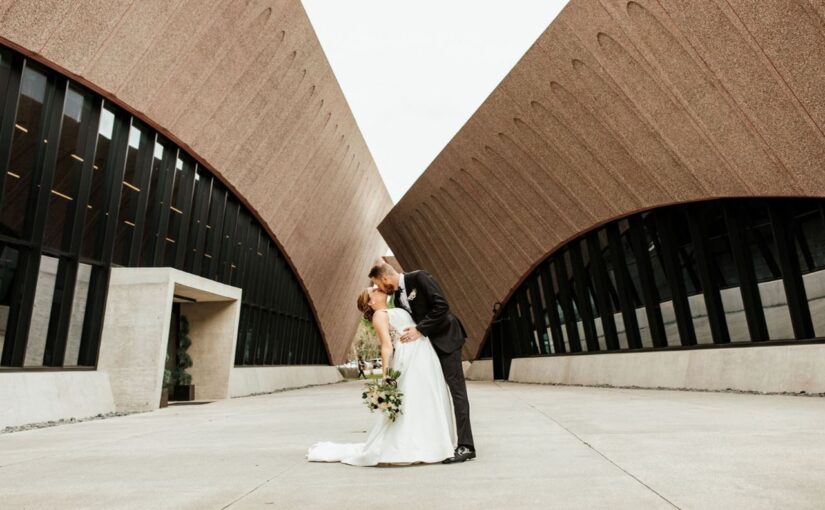 The groom dipping his bride and giving her a kiss outside the Winter Park Events Center venue