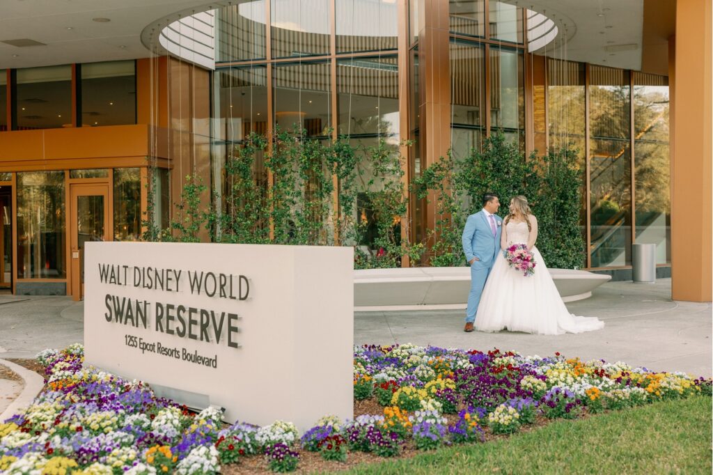 Catherine and Gerardo Maravilla Wedding on 2/8/2025. Bride and groom in their wedding attire standing outside the hotel in front of the sign