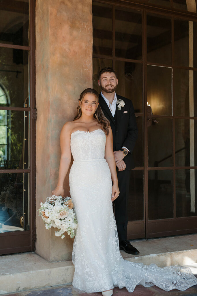Bride and Groom in front of a column holding flowers. Wedding Rentals Orlando A Sparkling Start: Trinity and Tim's Unforgettable Wedding Day