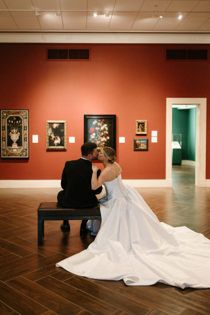 Bride and Groom kissing at The Museum of Fine Arts in St Petersburg Florida with Wedding Event Rentals provided by A Chair Affair.