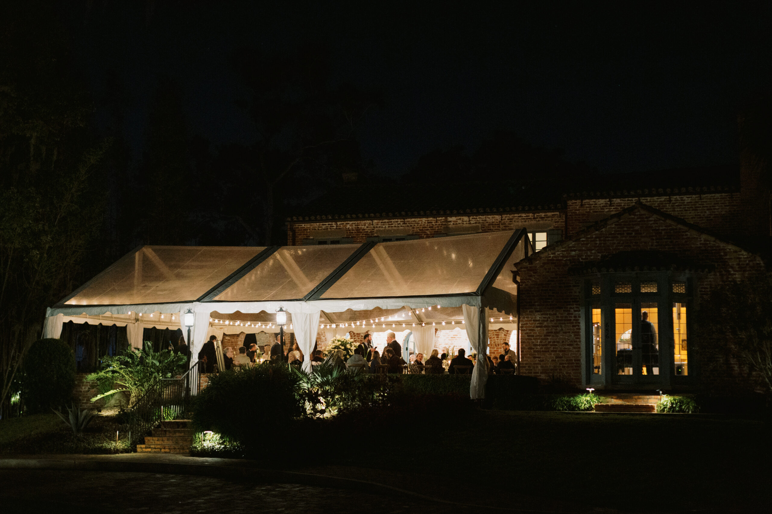 Night time view of reception at Casa Feliz under clear top tent