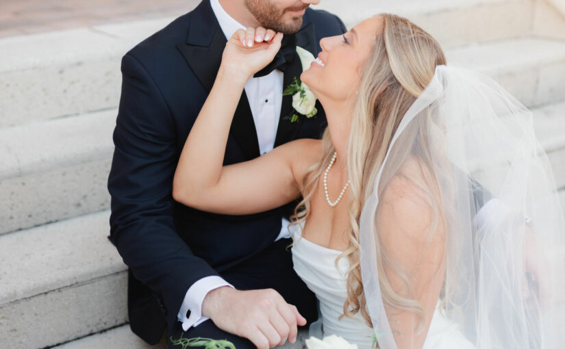 Bride gazing at groom on steps. Orlando Wedding Rentals. Navy Octo Chargers from A Chair Affair