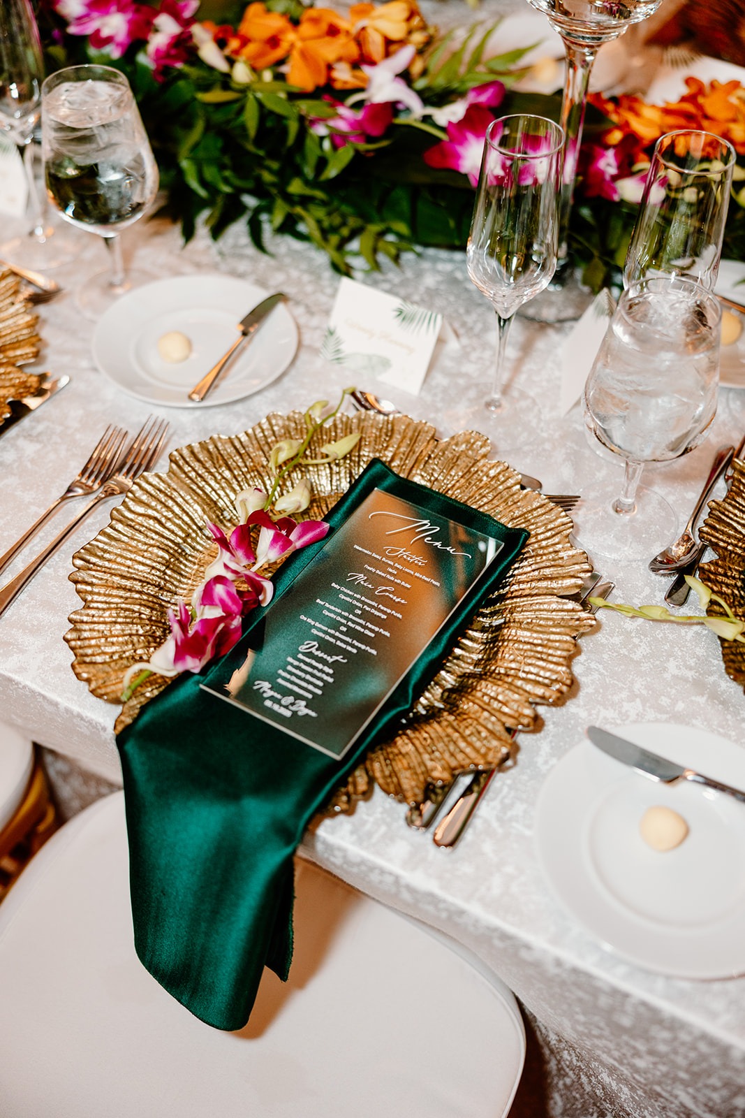 Gold Sea Foam Charger under emerald linen with gold flatware. Rentals provided by A Chair Affair. Orlando Wedding Rentals