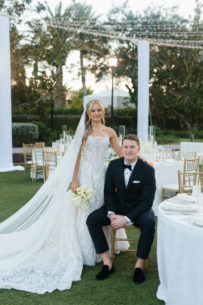 Bride and Groom posed at table at reception. Orlando Wedding Rentals. Orlando Rentals. Orlando Glassware Rentals. Central Florida Rentals