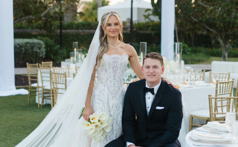 Bride and Groom posed at table at reception. Orlando Wedding Rentals. Orlando Rentals. Orlando Glassware Rentals. Central Florida Rentals