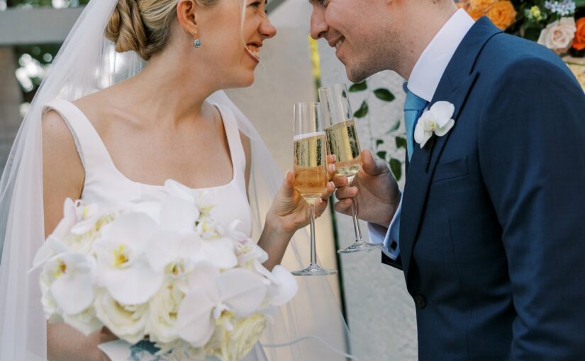 Bride and Groom with champagne Glasses. A Sun-Drenched Celebration: Keaton and Matthew’s Stunning Wedding at The Vinoy