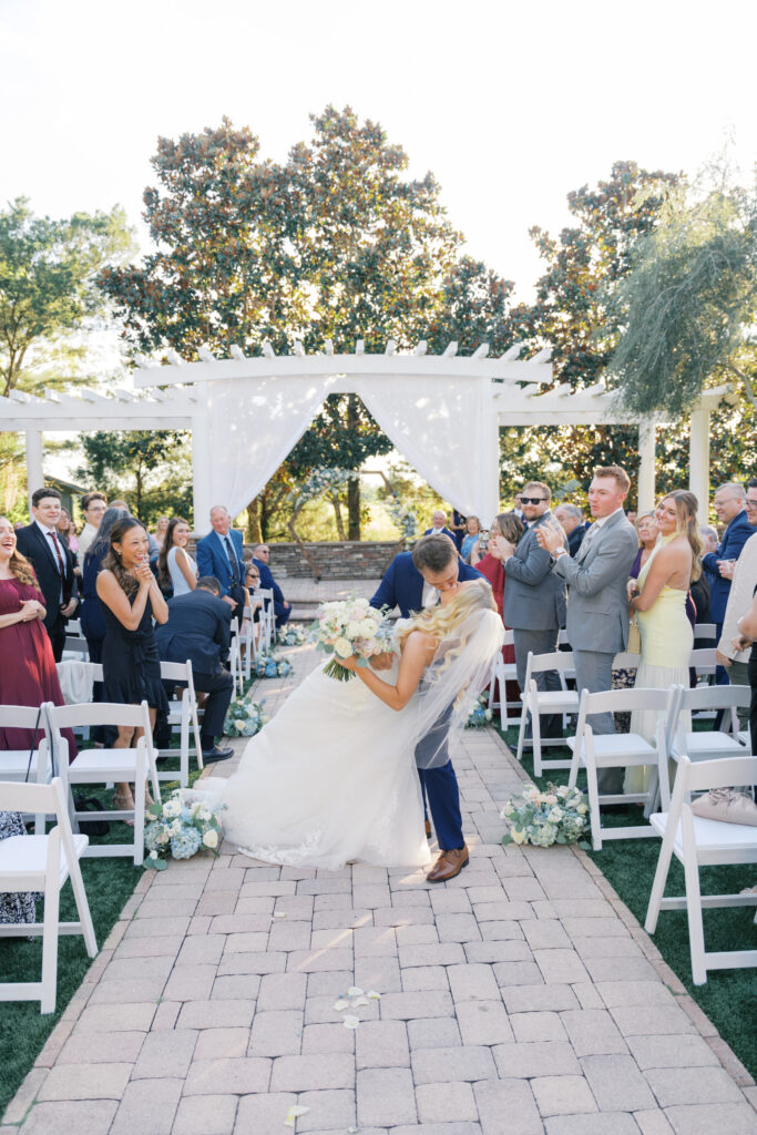 Bride and Groom kissing after ceremony. Orlando Wedding Rentals. Orlando Chair Rentals. Orlando Chiavari Chair Rentals. Orlando Charger Rentals.