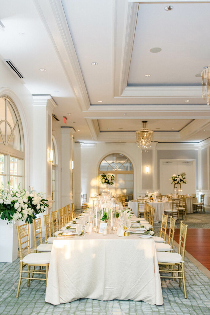 Table view long with Gold Chiavari Chairs and Gold Rimmed Chargers from A Chair Affair. Sarasota Wedding Rentals. Sarasota Chiavari Rentals. Central Florida Wedding Rentals. Tampa Wedding Rentals. Tampa Chair Rentals.