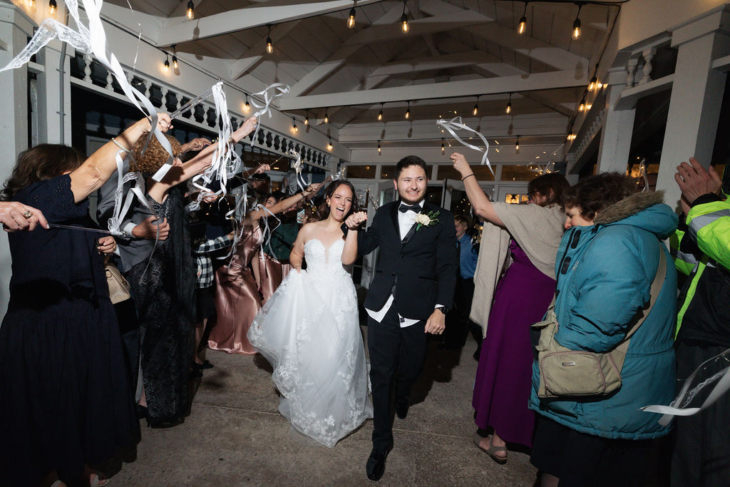 Bride and Groom leaving the reception with streamers.