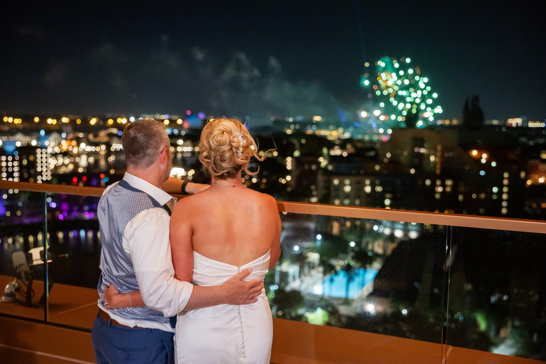 Bride and groom watching fireworks from The Vue terrace. A Magical Celebration at The Walt Disney World Swan Reserve