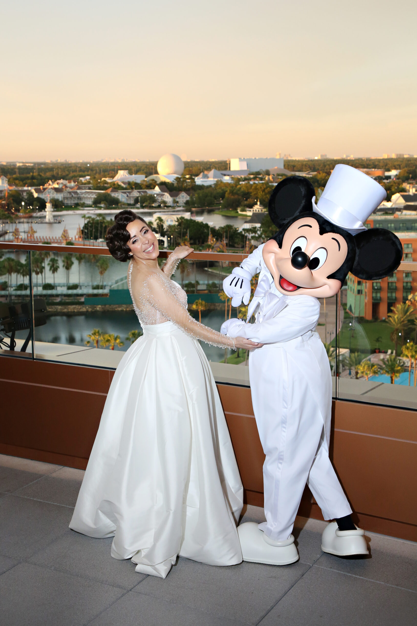 Bride and Mickey Mouse on the terrace at The Vue. Central Florida Wedding Rentals. Orlando Wedding Rentals. Chiavari Chair Rentals. Gold Chiavari Chairs. Walt Disney World. Swan and Dolphin Resort.