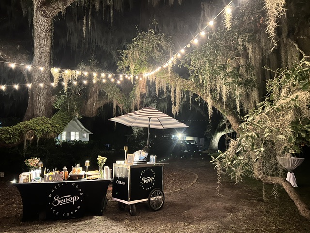 Scoops Wheelie Good Ice Cream Cart under lights and hanging moss.